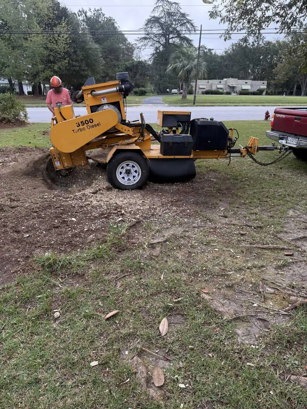 Stump grinding machine removing tree stump from yard